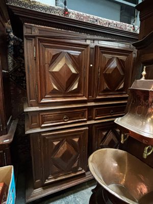 une grande armoire en bois sur laquelle est posé un bol en métal