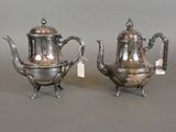 pair of antique silver teapots on stands with tags on them