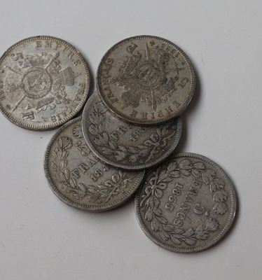 plusieurs pièces d'argent empilées les unes sur les autres sur une surface blanche