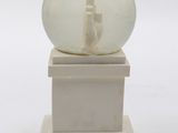 a snow globe sitting on top of a white pedestal