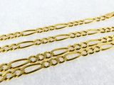 a pair of gold chain bracelets on a white surface