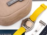 the watch has a yellow strap and a black case with a silver clasp