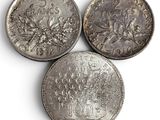 three different types of silver coins on a white surface