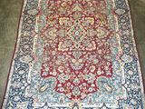 a red and blue rug with a floral design on it