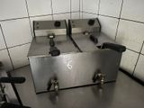 two deep fryers sitting on a counter in a kitchen