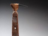 sculpture représentant un oiseau perché au sommet d'une haute tour