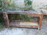 une table en bois surmontée d'une étagère, dans une cour