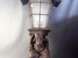 a statue of a man holding a lamp on his head