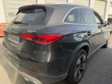 the rear end of a black mercedes suv parked in front of a building