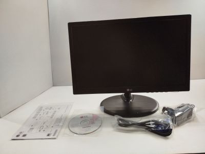 un écran d'ordinateur posé sur un bureau, à côté d'un lecteur DVD