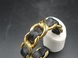 bague à maillons plaquée or avec un bracelet en cuir noir