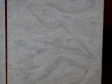 two pieces of marble sitting on top of a rug next to a bed