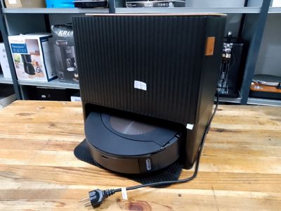 a black speaker on top of a wooden table in a room