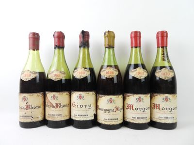 six bouteilles de vin sont alignées sur une surface blanche