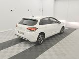 the rear end of a white car parked in a garage