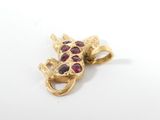 a close up of a giraffe pendant with a red stone in it