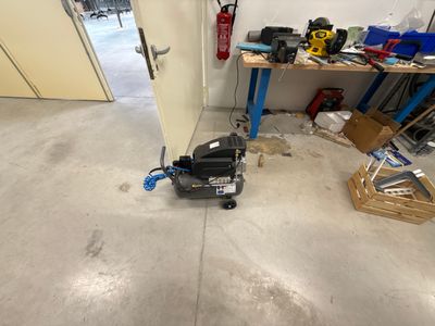 a small machine that is sitting on the floor in a garage
