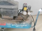 un petit compresseur d'air posé par terre à côté d'un chat
