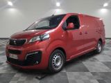 La camionnette rouge est garée sur un sol en dalles à damier.