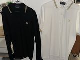 two men ' s shirts hanging on a rack in a clothing store
