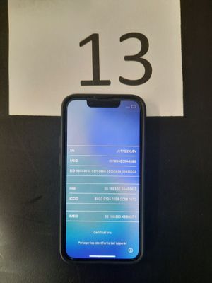 Un iPhone est posé sur une table à côté d'un panneau sur lequel figure le chiffre treize.