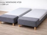two gray ottomans sitting on top of a wooden floor next to a white wall