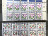 two stamps with flowers on them are on display in a glass case