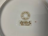 a white plate with a gold emblem on it