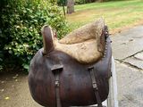 a horse saddle that is sitting on a metal stand