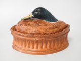a ceramic duck sitting on top of a box