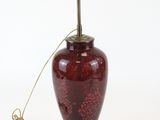 an image of a red vase with a lamp on top of it