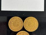 a close up of three gold coins sitting on top of a table