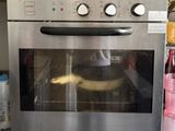 un four argenté avec une banane à l'intérieur, posé sur le plan de travail