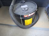 un aspirateur posé par terre à côté d'un sac