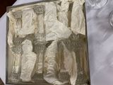 a box of silverware sitting on a table next to a glass of water