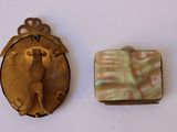 two pieces of metal and mother of pearl on a white surface