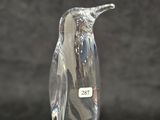 an image of a glass penguin figurine sitting on a black surface