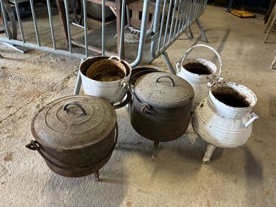 Plusieurs casseroles et poêles sont alignées par terre