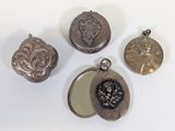 four antique silver lockes and a mirror on a white surface