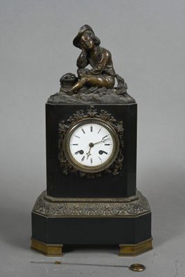 a small clock with a statue on top of it