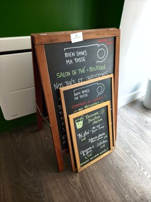 un tableau noir sur lequel est inscrit le menu, placé devant un radiateur