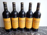 four bottles of wine are lined up on a table