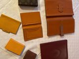 plusieurs portefeuilles Louis Vuitton posés sur une surface blanche