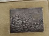 a metal plaque with a picture of a man in a boat