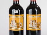 deux bouteilles de vin rouge posées l'une à côté de l'autre sur une surface blanche