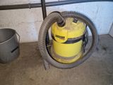 a yellow canister with a hose and a bucket next to it