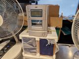 une radio posée sur une table à côté d'un ventilateur