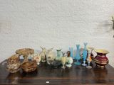 many different vases on a wooden table with a white wall in the background