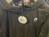 a green jacket hanging on a hanger in a store