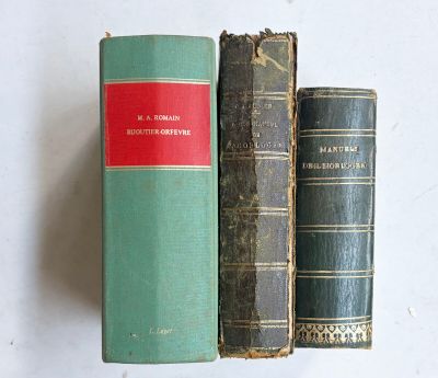 trois livres posés sur une table blanche